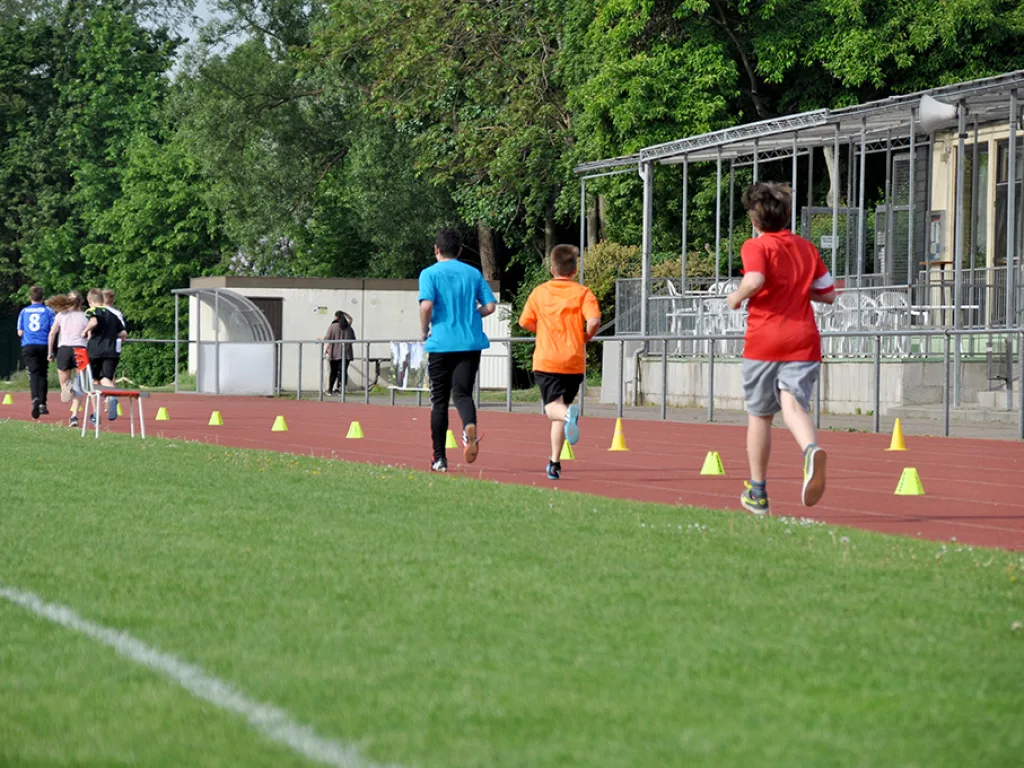Läufer auf der Tartanbahn vor dem Sportheim.